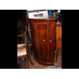 An inlaid mahogany bow fronted corner cabinet