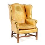 A 19TH CENTURY MAHOGANY UPHOLSTERED LEATHER WINGBACK ARMCHAIR