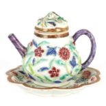 A 19TH CENTURY CHINESE HIGH RELIEF FAMILLE ROSE TEAPOT AND COVER ON STAND