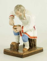 AN EARLY 20TH CENTURY RUSSIAN PORCELAIN FIGURE DEPICTING A COBLER