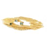 A STYLISH 14CT GOLD AND EMERALD PIN BROOCH