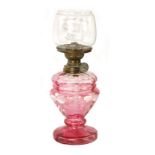 A MINIATURE CRANBERRY GLASS OIL LAMP