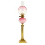 A VICTORIAN BRASS AND CRANBERRY GLASS OIL LAMP