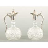 AN UNUSUAL PAIR OF HALF SIZE SILVER METAL MOUNTED CUT GLASS CLARET JUGS CIRCA 1900