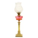 A VICTORIAN BRASS AND CRANBERRY GLASS OIL LAMP