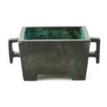 A CHINESE PATINATED BRONZE RECTANGULAR CENSER with cutout handles and bracket feet 19cm wide 11.