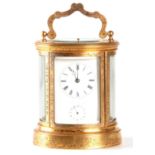 JAPY FRERES AND CO. A 19TH CENTURY ENGRAVED GILT OVAL CASED REPEATING FRENCH CARRIAGE CLOCK