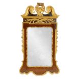 A GEORGE II WALNUT AND PARCEL GILT HANGING MIRROR OF GENEROUS SIZE