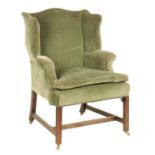 A GEORGE III WING-BACK MAHOGANY FRAMED UPHOLSTERED ARMCHAIR
