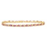 A LADIES 14CT YELLOW GOLD RUBY AND DIAMOND TENNIS BRACELET