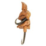 AN EARLY 20TH CENTURY BLACK FOREST CARVED LINDENWOOD COAT HOOK