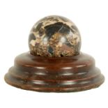 A 19TH CENTURY MARBLE BALL ON TURNED TREENWARE MAHOGANY STAND