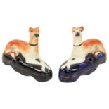 A PAIR OF 19TH CENTURY STAFFORDSHIRE RECUMBENT HOUNDS