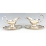 A LARGE PAIR OF 19TH CENTURY SILVER PLATED SAUCE BOATS ON FIXED STANDS