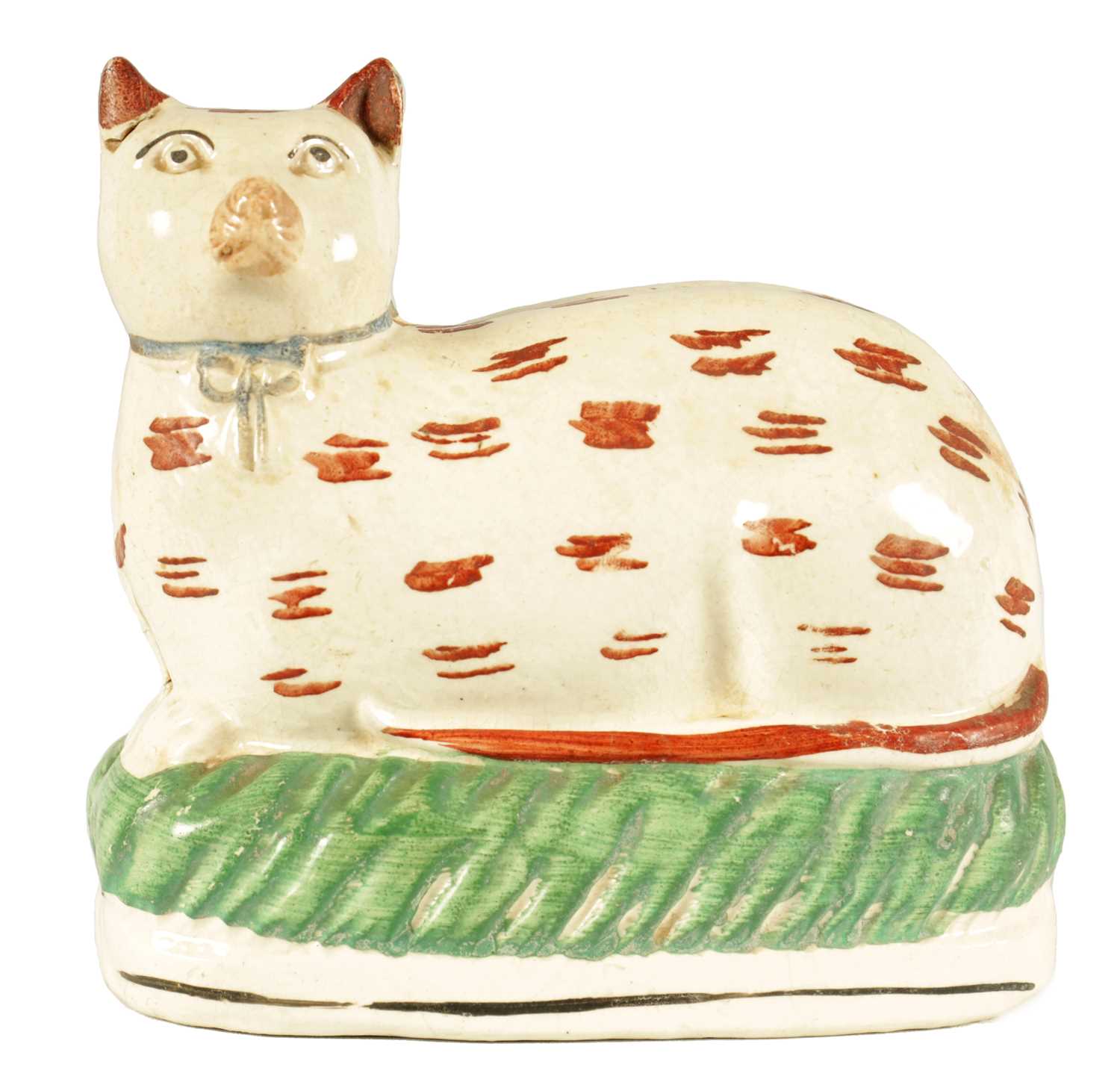 AN EARLY 19TH CENTURY STAFFORDSHIRE MODEL ON A RECUMBENT CAT