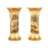 JAMES STINTON. A PAIR OF ROYAL WORCESTER GILT EDGED FLARED CYLINDRICAL CABINET VASES