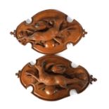 A PAIR OF LATE 19TH CENTURY BLACK FOREST CARVED LINDEN WOOD PLAQUES
