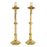 A PAIR OF ARTS AND CRAFTS STYLE GOTHIC CAST BRASS CANDLESTICKS