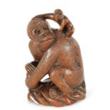 A 19TH CENTURY CARVED HARDWOOD SCULPTURE OF A MONKEY