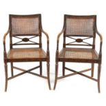 A PAIR OF REGENCY BERGERE PAINTED SIMULATED SATINWOOD OPEN ARMCHAIRS