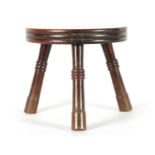AN EARLY/MID 19TH CENTURY YEW WOOD LOW STOOL