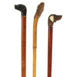 A SELECTION OF THREE CARVED DOG'S HEAD WALKING STICKS