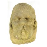 AN EARLY CARVED STONE MASK HEAD