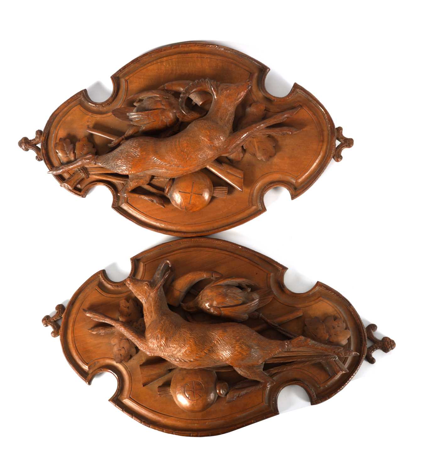 A PAIR OF LATE 19TH CENTURY BLACK FOREST CARVED LINDEN WOOD PLAQUES