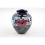 Moorcroft Orchid pattern squat vase with impressed and singed mark to base. 10cm in height