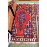 Red ground Persian rug with central medallion and tassel ends. 150 x 95cm