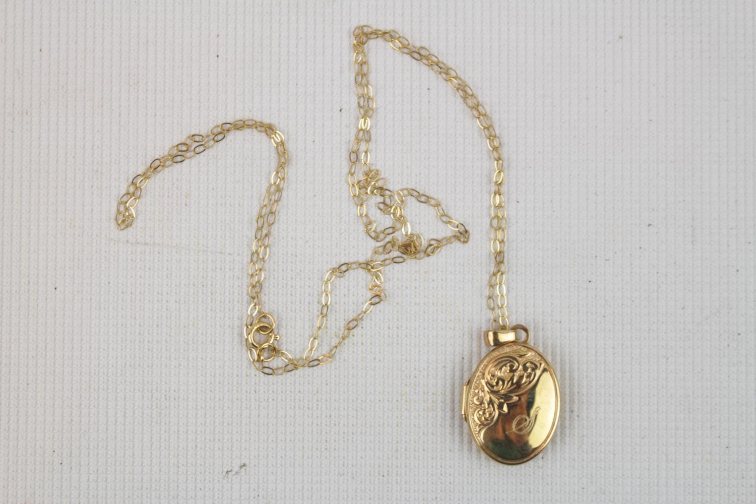 Ladies Yellow metal oval locket on 9ct gold chain