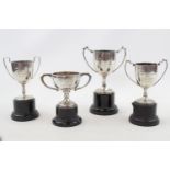 Collection of 4 Silver two handled miniature trophies on pedestal bases