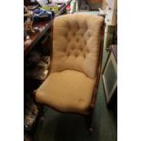 Victorian button back chair on mahogany frame over turned legs and caster feet