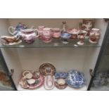 2 Shelves of assorted Clarice Cliff Transfer printed tableware and cabinet ware