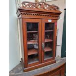 Edwardian glazed 2 door collectors cabinet with dentil moulding and pierced pediment