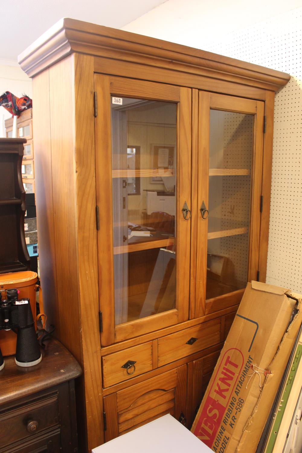 Pine glazed bookcase with cupboard under tier