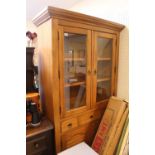 Pine glazed bookcase with cupboard under tier