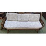 A Ercol Dark elm day bed, raised on tapering column supports, with upholstered seat length 210cm.