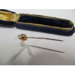 A 15ct gold stick pin set opal flower and another simulated pearl stick pin