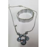 A pretty faceted blue stone necklace on chain and a silver coloured flexible bracelet