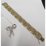 A filigree design and marcasite bracelet marked 835 and a bow brooch