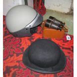 A bike helmet, bowler hat and a pair of binoculars