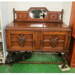 A small 1920s oak sideboard with mirror back, two panelled cupboards on barleytwist supports