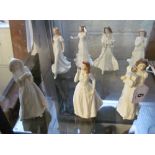 Seven white Royal Doulton figures; Joy, Christmas Carol, Friendship, another, Christmas Parcels,