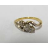 An 18ct gold three stone diamond cross over ring size M 2.8g