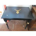 A black painted side table with gilt stag motif