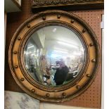 A circular convex mirror in gilt ball frame