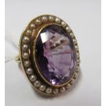 A gold coloured ring set amethyst and pearls size L/M