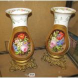 A pair of Continental porcelain vases white ground with reserves of flowers on gilt metal bases (one