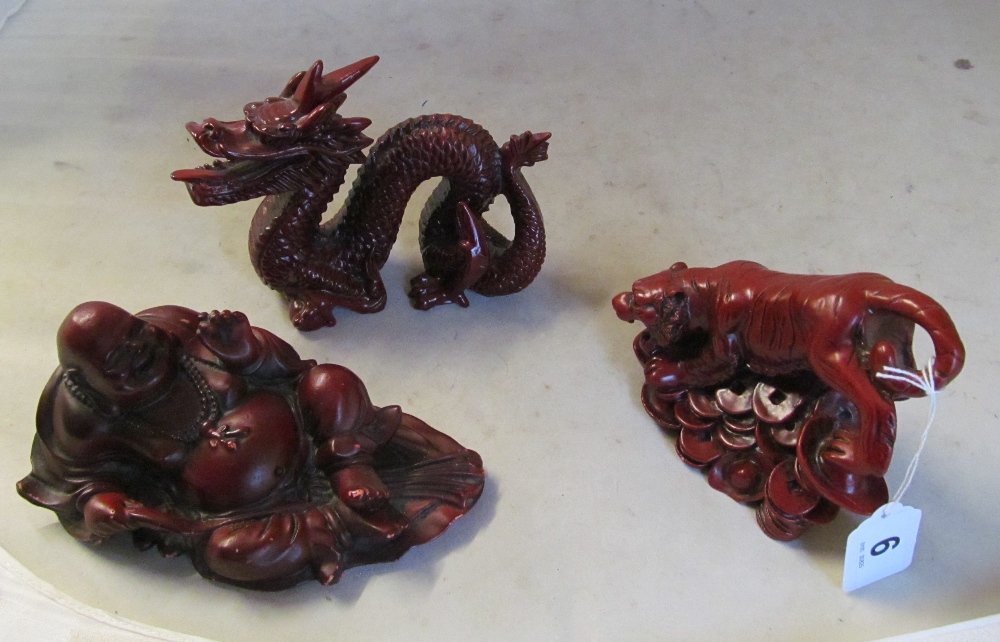 Three Chinese resin red figures:- resting Buddha, tiger and dragon